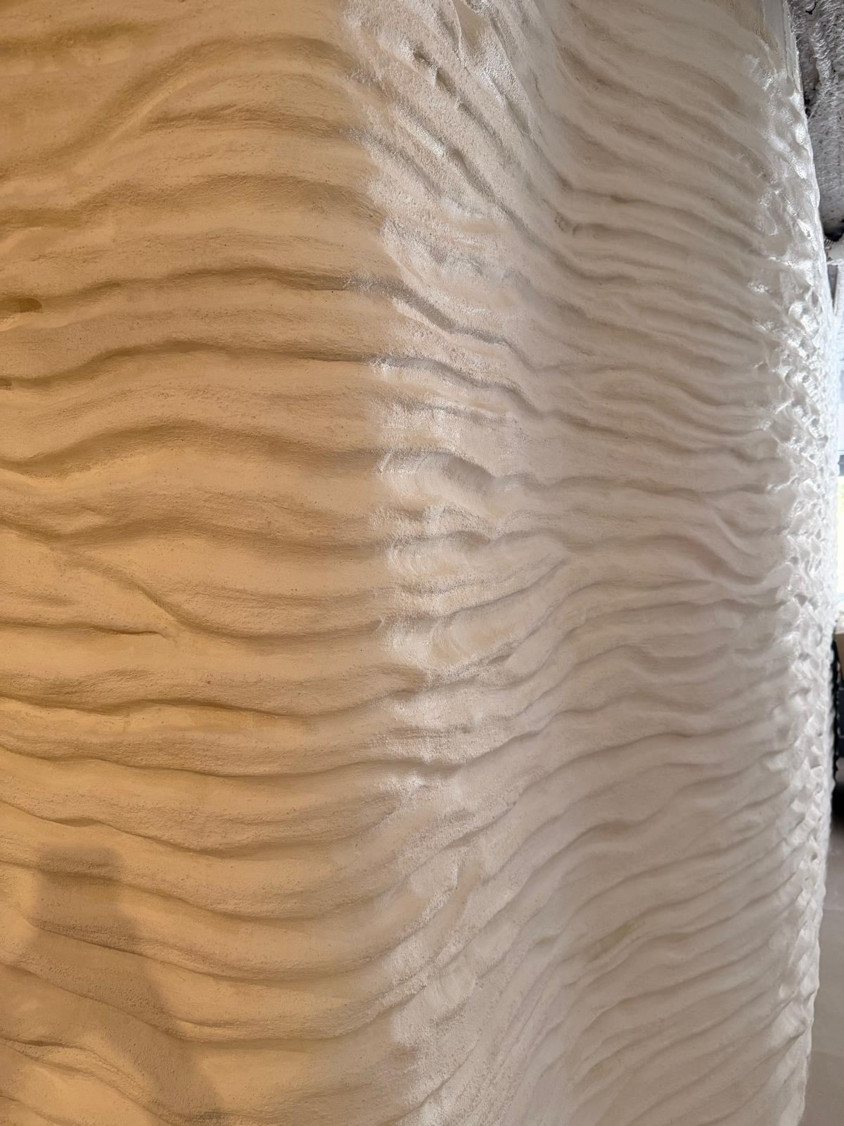 Pared de mortero con textura ondulada en plena obra, antes de pintar